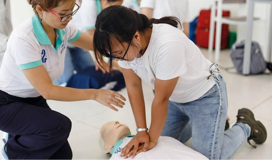 Woman practicing CPR on a dummy mannequin.