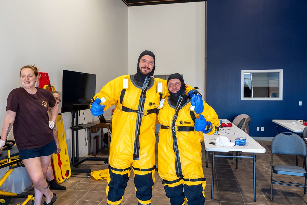 People in yellow protective suits indoors.